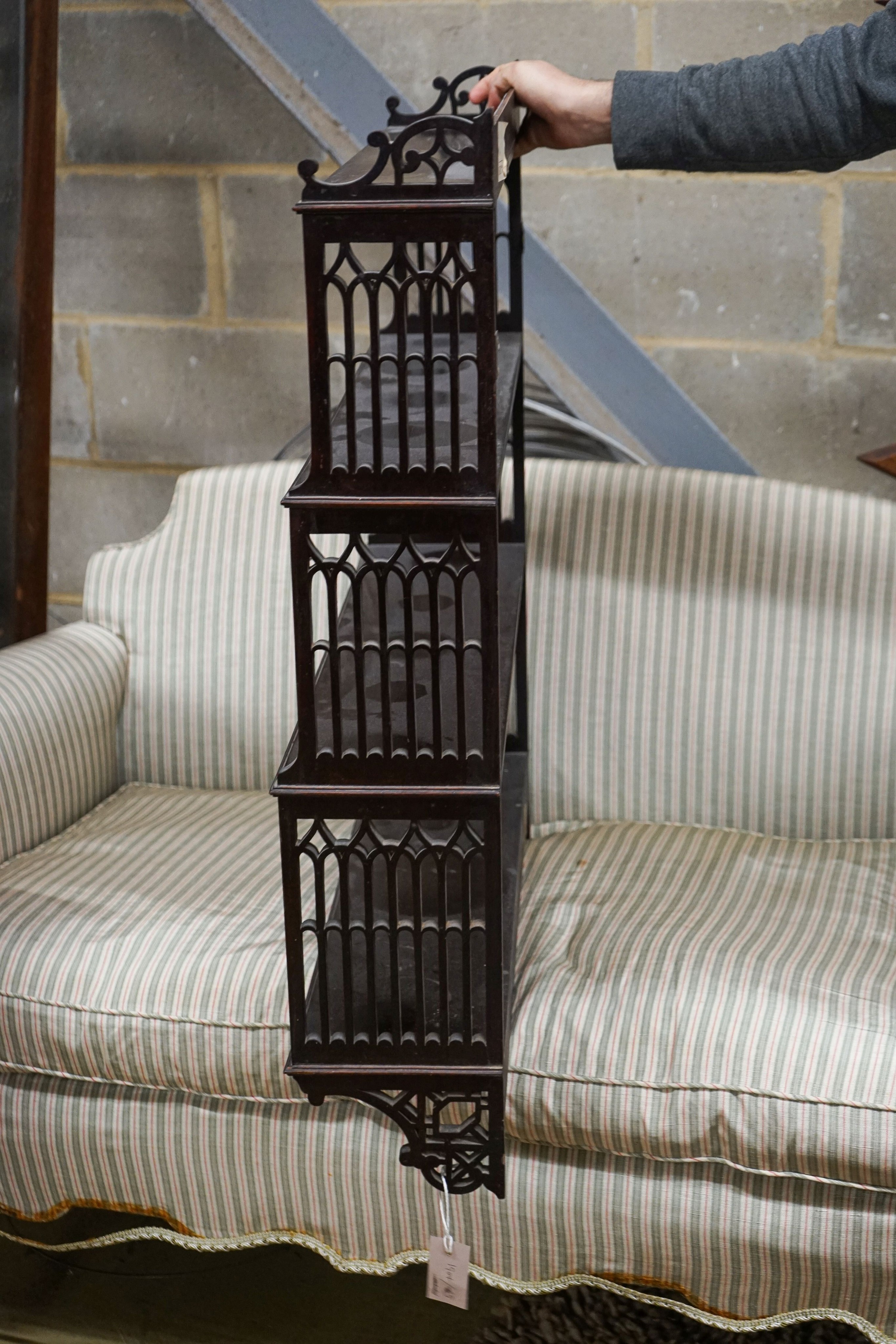 A George III style fret cut mahogany hanging four-tier wall shelf, width 70cm, depth 18cm, height 88cm